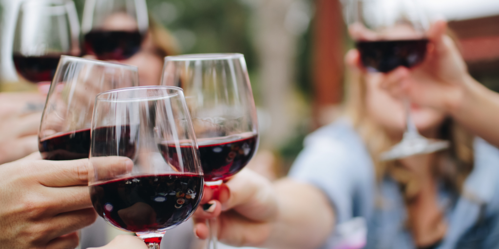 people holding glasses of red wine